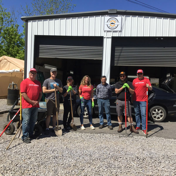 group of volunteers standing outside the working wheels garage